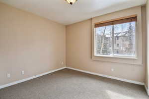 Spare room featuring carpet flooring and baseboards