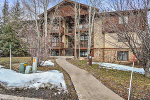 Snow covered property with stairway