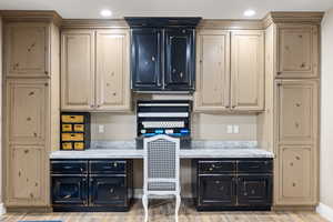 Interior space with cream cabinetry, recessed lighting, and built in study area