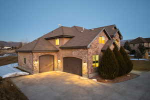 View of front of property with an attached garage, a mountain view, and driveway