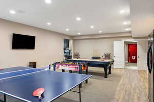 Game room with light wood-style flooring and recessed lighting