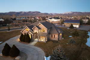 View of front of property with stucco siding, a residential view, a mountain view, and a shingled roof