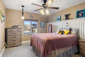 Bedroom featuring carpet flooring, baseboards, and ceiling fan