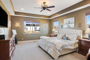 Bedroom featuring baseboards, multiple windows, and light colored carpet