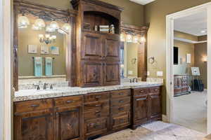 Bathroom featuring tile patterned flooring, double vanity, baseboards, and a sink