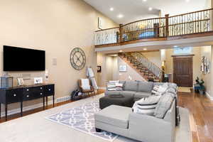 Living area with a towering ceiling, and wood finished floors