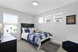 Bedroom featuring baseboards and light carpet