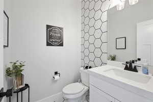 Bathroom with vanity, toilet, and baseboards