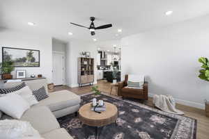 Living room with recessed lighting, light wood-type flooring, baseboards, and ceiling fan