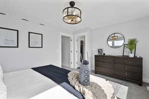 Carpeted bedroom featuring visible vents and baseboards