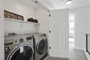 Laundry room featuring laundry area, washing machine and dryer, and baseboards