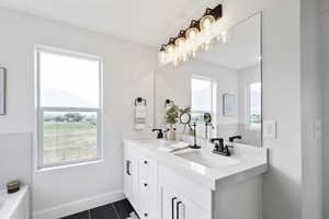 Full bath with tile patterned floors, double vanity, a bathtub, and a sink