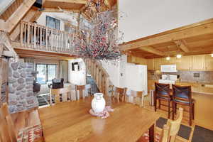 Dining area featuring light wood-type flooring, beamed ceiling, wooden ceiling, and a towering ceiling