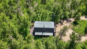 Aerial view of property and surrounding area featuring a heavily wooded area