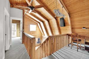 Corridor with beam ceiling, high vaulted ceiling, wood ceiling, and carpet flooring