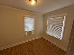 Spare room with wood finished floors, baseboards, and ornamental molding