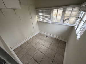 Spare room featuring light tile patterned floors, visible vents, and baseboards