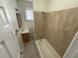 Full bath with vanity, baseboards, bathtub / shower combination, tile patterned floors, and toilet