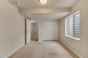 Unfurnished bedroom with multiple windows, carpet, and baseboards