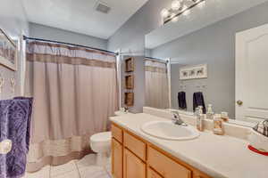 Full bath featuring vanity, visible vents, tile patterned flooring, curtained shower, and toilet