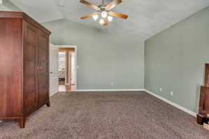 Unfurnished bedroom with baseboards, lofted ceiling, carpet, and a ceiling fan