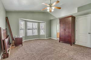 Unfurnished bedroom featuring baseboards, carpet floors, ceiling fan, and vaulted ceiling