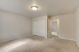 Unfurnished bedroom with a closet, baseboards, and carpet