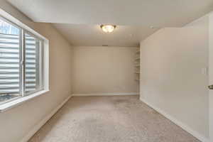 Carpeted empty room featuring baseboards