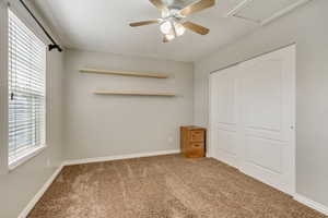 Unfurnished bedroom featuring a closet, baseboards, carpet, and ceiling fan