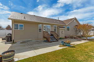 Back of property featuring a patio area, a lawn, roof with shingles, and fence