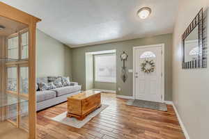 Living area with baseboards and wood finished floors