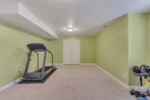 Exercise area featuring baseboards and carpet floors