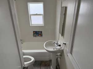 Bathroom featuring a sink, shower / bathing tub combination, toilet, and tile patterned floors