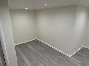 Spare room with recessed lighting, baseboards, and dark wood-style flooring