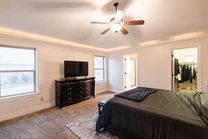 Bedroom with multiple windows, carpet, baseboards, and ceiling fan