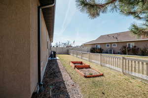 View of yard with central AC unit, a vegetable garden, and a fenced backyard