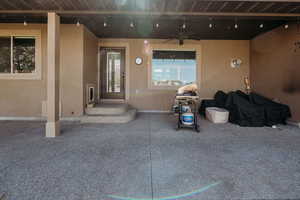 Entrance to property with stucco siding, ceiling fan, and a patio area