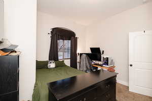 Bedroom featuring light colored carpet and baseboards