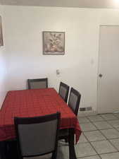 Dining area featuring light tile patterned flooring and visible vents