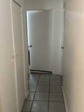 Hallway with light tile patterned floors and baseboards