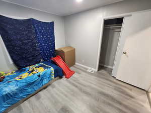 Bedroom with wood finished floors and visible vents