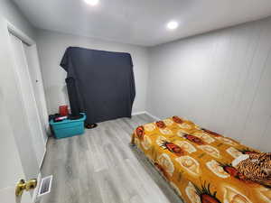 Bedroom with visible vents and wood finished floors