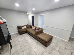 Living room with light tile patterned floors, recessed lighting, and baseboards