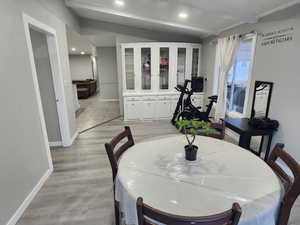 Dining area with lofted ceiling with beams, light wood-style flooring, recessed lighting, and baseboards