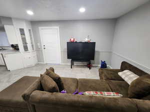 Living room featuring light tile patterned floors, recessed lighting, and baseboards