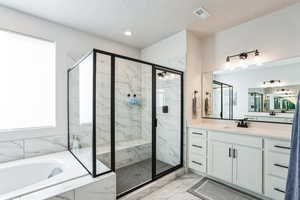 Full bath with visible vents, marble finish floor, a stall shower, a bath, and vanity