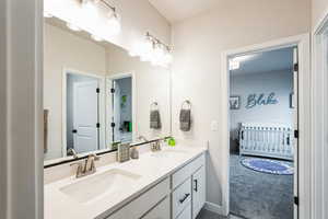 Full bathroom with double vanity, baseboards, and a sink