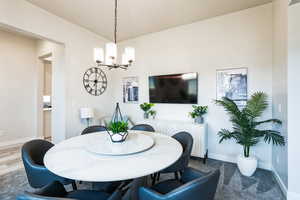 Dining room featuring baseboards, an inviting chandelier, and wood finished floors