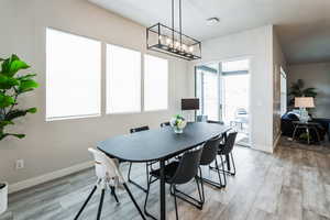 Dining room with baseboards, light wood-type flooring, and a chandelier