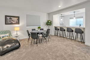 Carpeted dining area with a sink, baseboards, and recessed lighting